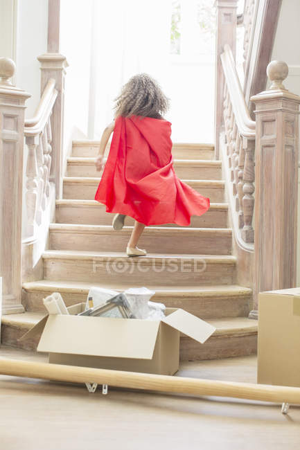 Chica joven corriendo escaleras arriba jugando - foto de stock