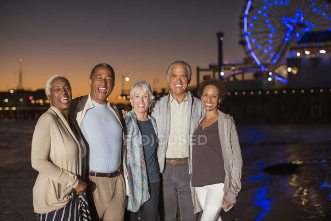 Portrait of senior friends on beach at night — Stock Photo