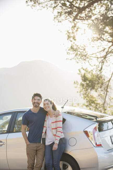 Portrait of happy couple outside car — Stock Photo