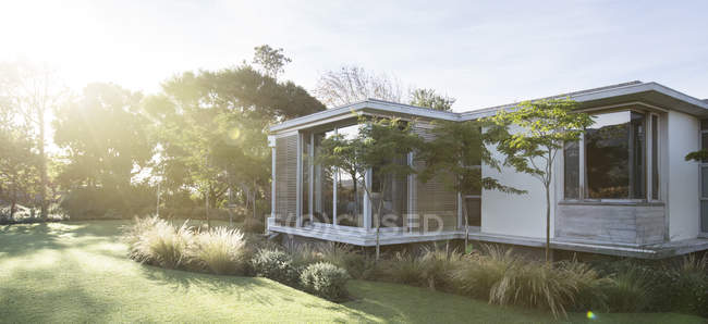 Giardino soleggiato e casa moderna — Foto stock