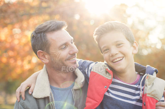 Ritratto padre e figlio sorridente davanti alle foglie autunnali — Foto stock