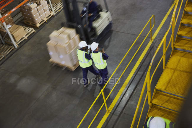 Carrelli elevatori e lavoratori in movimento nel magazzino di distribuzione — Foto stock
