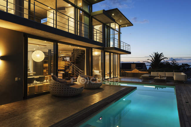 Luxury house with swimming pool illuminated at night — Stock Photo