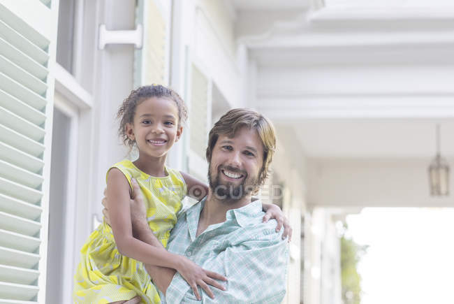 Отец держит дочь в руках на улице — стоковое фото