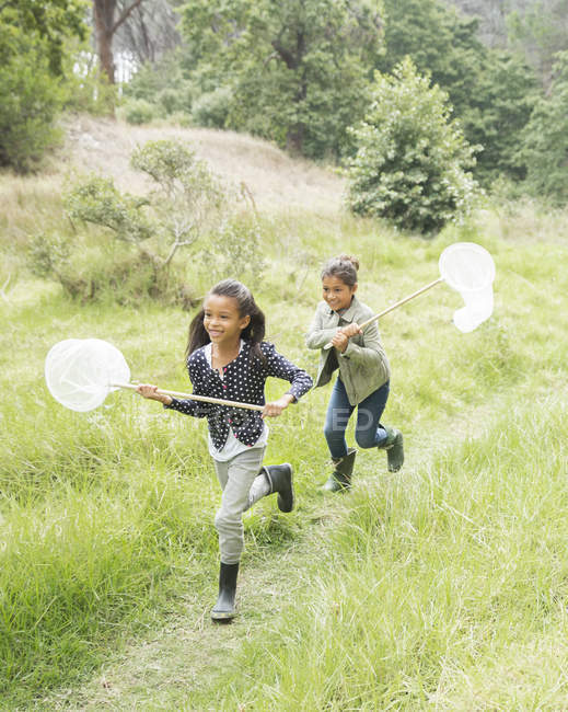 Mädchen benutzen Schmetterlingsnetze im Feld — Stockfoto