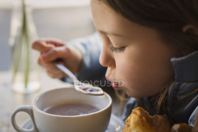 Close up girl blowing on hot soup — Stock Photo