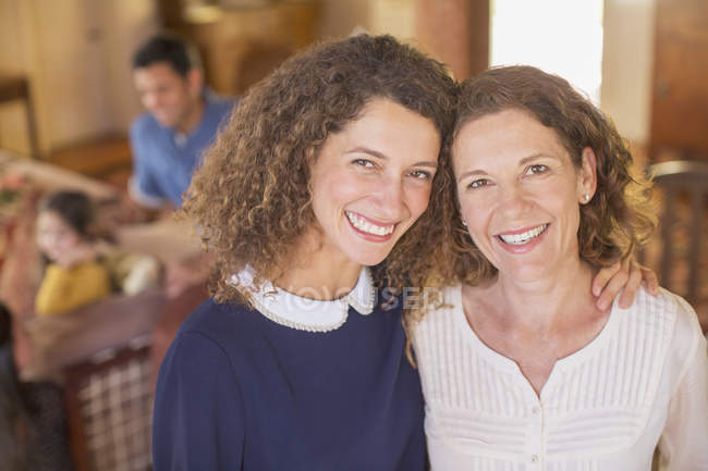 Mother and daughter hugging with family near — Stock Photo