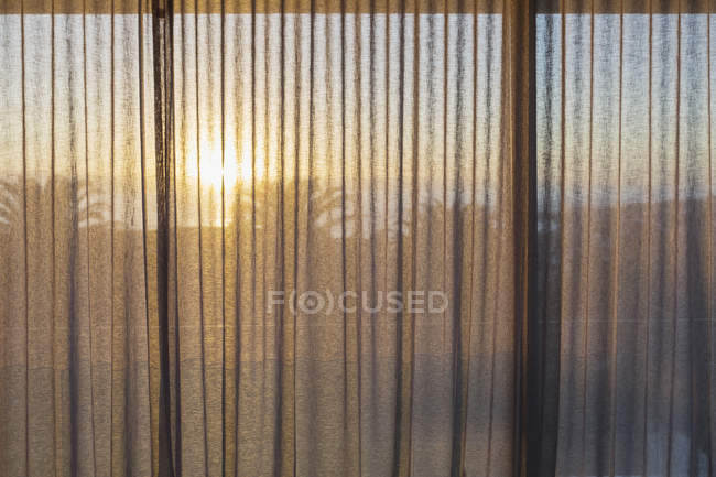 Pôr do sol tranquilo atrás de cortinas de gaze — Fotografia de Stock