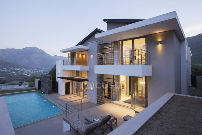 Moderna casa con piscina al atardecer - foto de stock