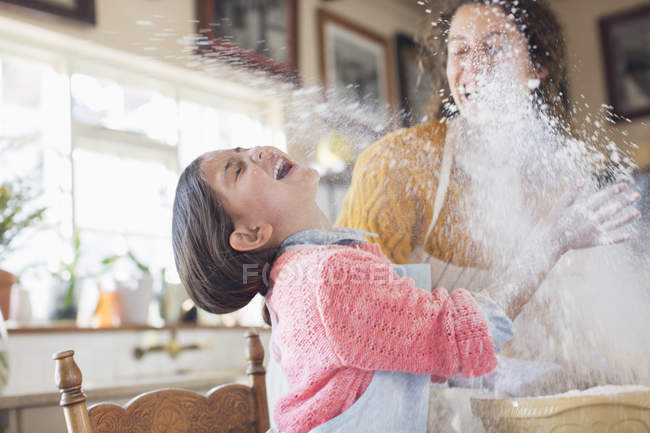 Mutter und Tochter spielen mit Mehl in der Küche — Stockfoto