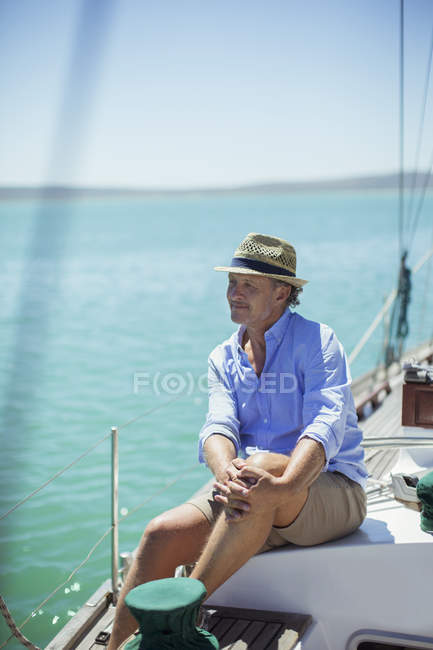 Старший мужчина, сидящий на лодке на открытом воздухе — стоковое фото