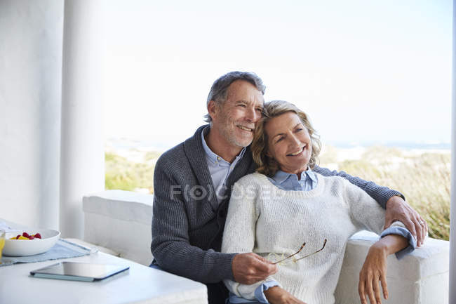 Усміхнена старша пара розслабляється на патіо — стокове фото