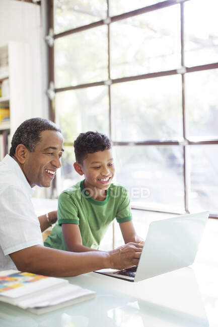 Дід і онук використовуючи ноутбук — стокове фото