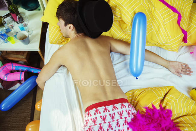 De cima vista do homem dormindo na cama após a festa — Fotografia de Stock