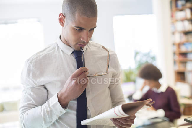 Businessman reading newspaper in living room — Stock Photo