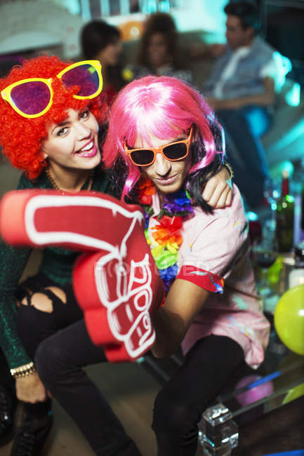 Couple portant des costumes à la fête et posant à la caméra — Photo de stock