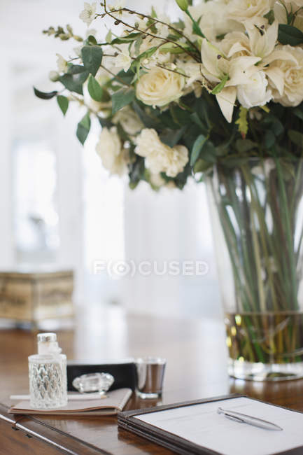 Bouquet de roses et bloc-notes sur bureau de luxe — Photo de stock