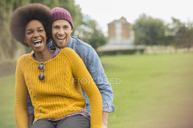 Feliz pareja joven montar bicicleta juntos en el parque - foto de stock