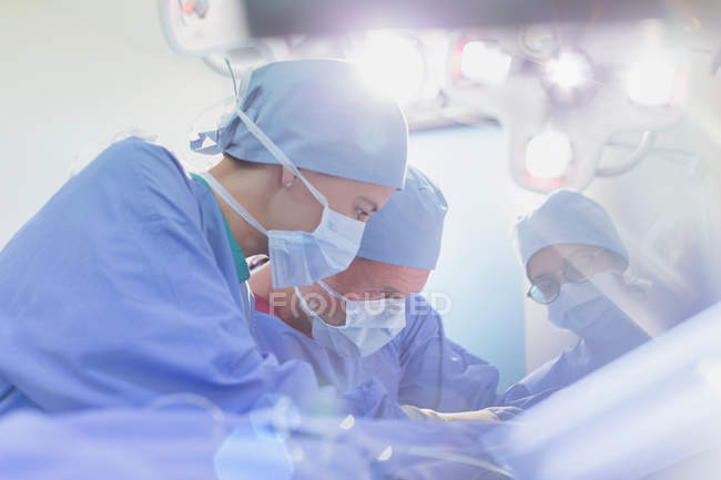 Cirurgiões focados realizando cirurgia na sala de cirurgia — Fotografia de Stock