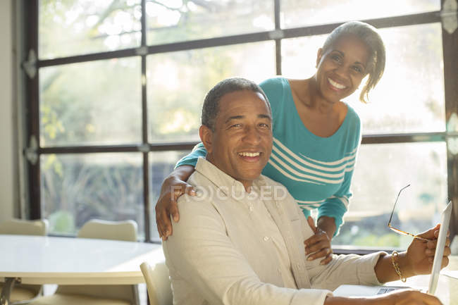 Портрет улыбающейся пожилой пары за ноутбуком — стоковое фото
