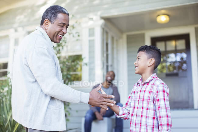 Grandfather and grandson exchanging special handshake outdoors — Stock Photo