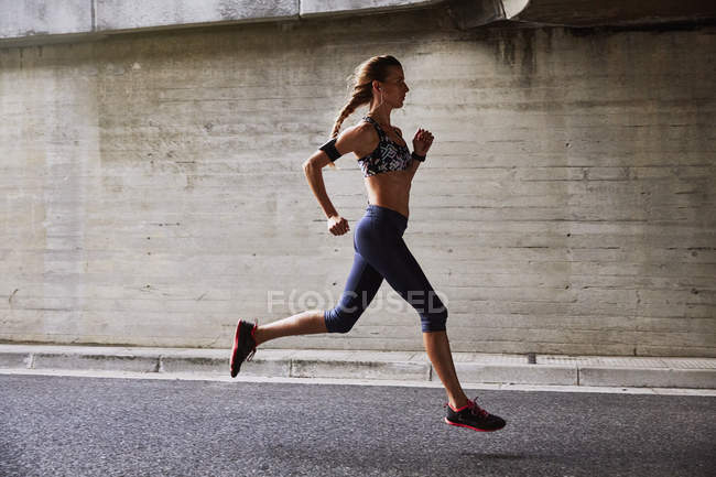 Läuferin läuft auf Stadtstraße — Stockfoto