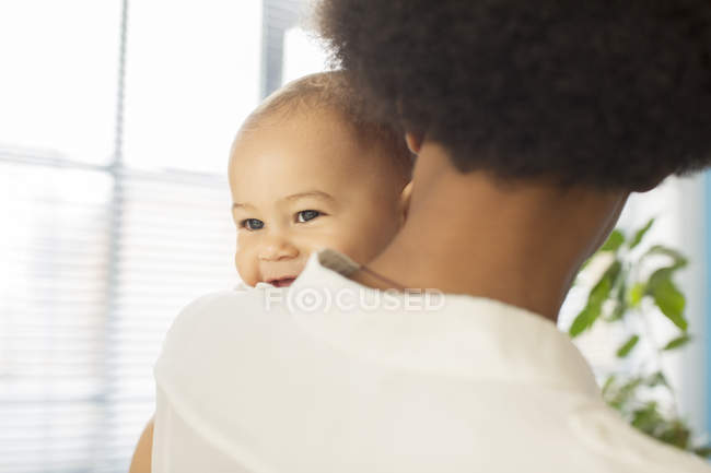 Mère portant bébé garçon à la maison — Photo de stock