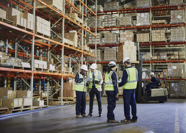 Les travailleurs se rencontrent et parlent dans un entrepôt de distribution — Photo de stock