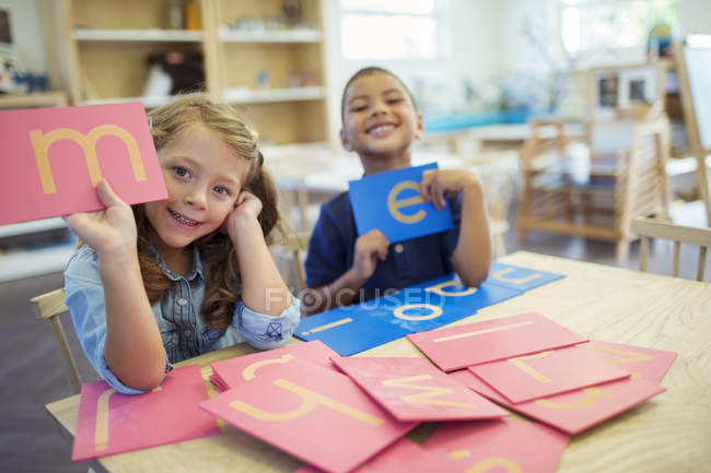 Estudiantes sosteniendo cartas en clase - foto de stock
