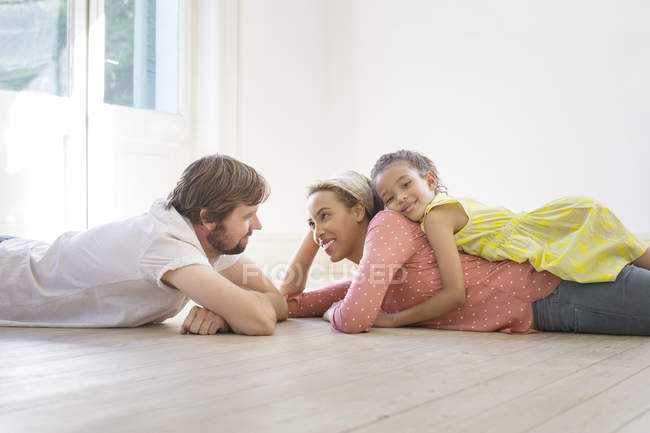 Familia tendida en el suelo juntos en el espacio de vida - foto de stock