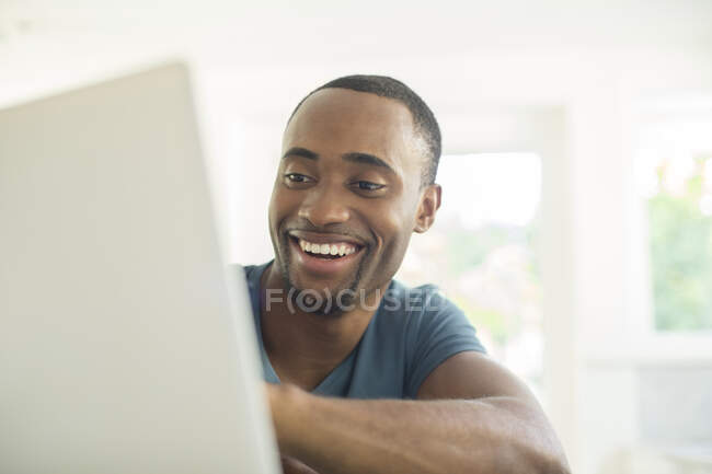 Hombre feliz usando portátil - foto de stock
