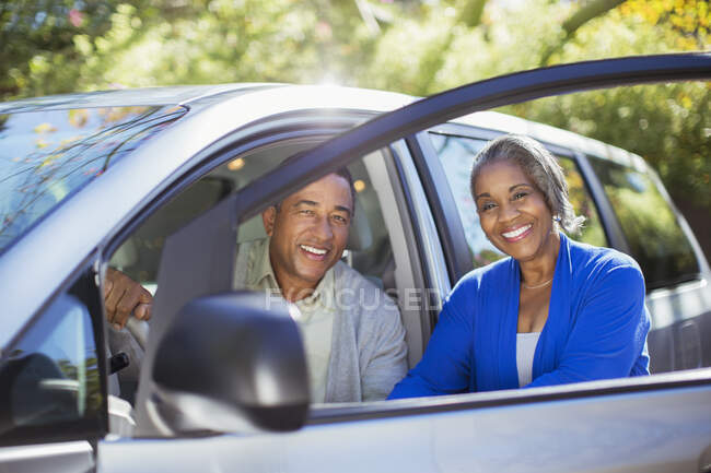 Portrait de couple heureux à l'intérieur et à l'extérieur de la voiture — Photo de stock