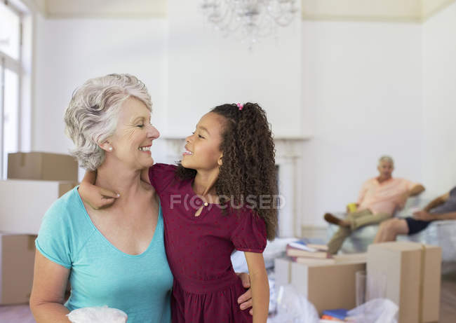 Grandmother and granddaughter hugging in living space — Stock Photo