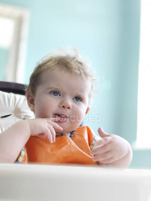 Bebê menina comendo em cadeira alta — Fotografia de Stock