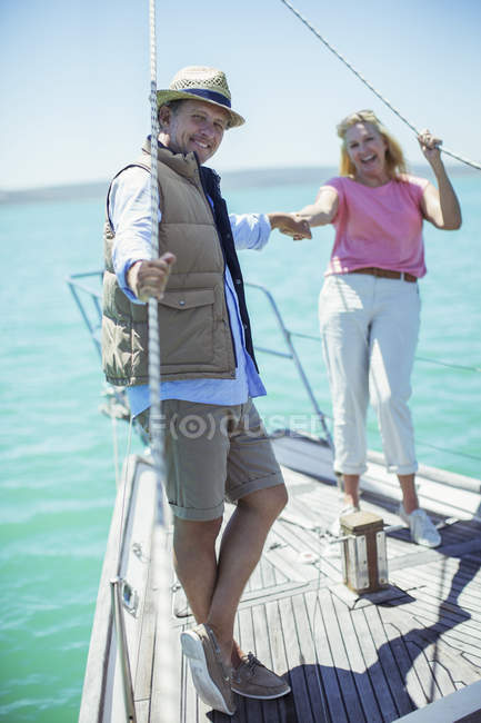 Coppia che si tiene per mano sulla barca — Foto stock