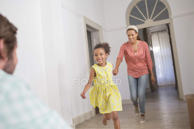 Madre e hija corriendo hacia el padre - foto de stock