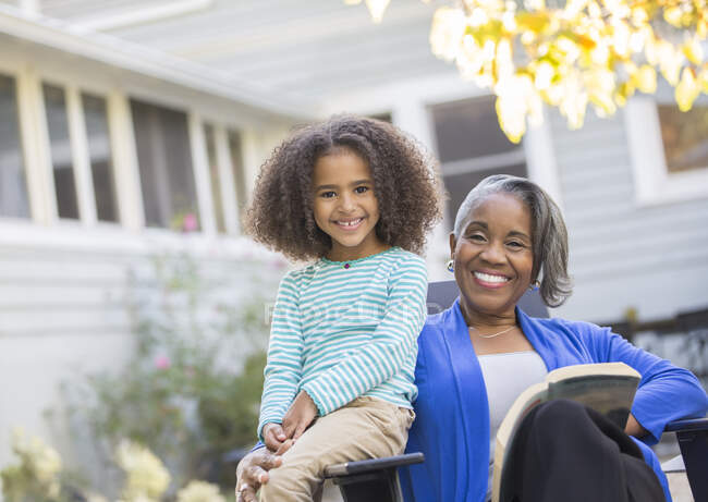 Portrait of happy grandmother and granddaughter on patio — Stock Photo