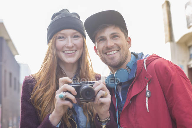 Couple taking photographs with camera in city — Stock Photo
