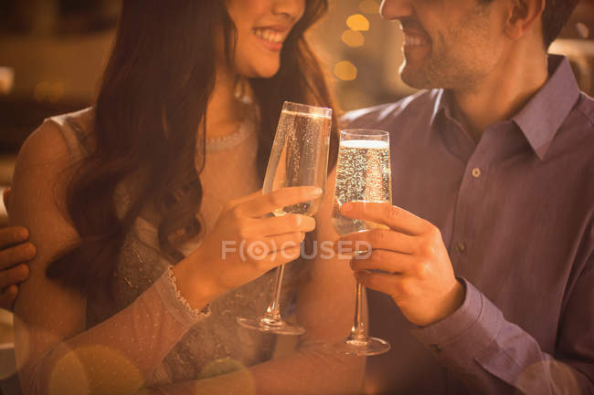 Casal afetuoso tostando flautas de champanhe — Fotografia de Stock