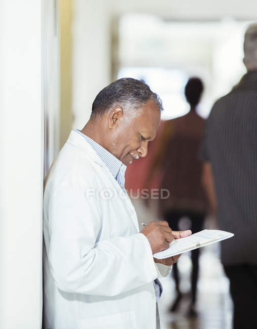 Лікар пише на медичній картці в лікарні — стокове фото