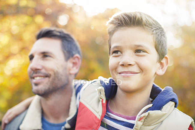 Крупным планом улыбающиеся отец и сын обнимаются на открытом воздухе — стоковое фото