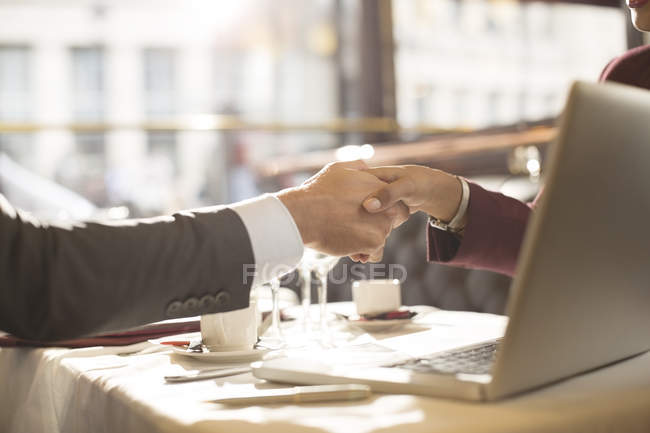 Imagen recortada de gente de negocios estrechando la mano en el restaurante - foto de stock