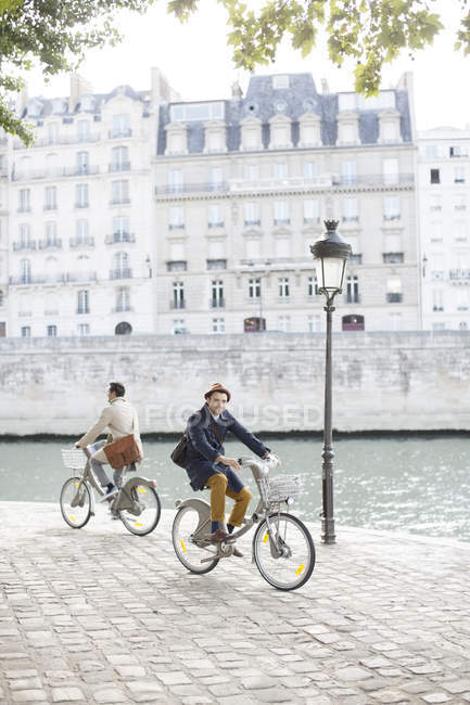 Hommes en vélo le long de la Seine, Paris, France — Photo de stock