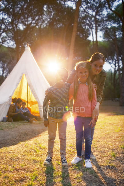Students and teacher smiling by teepee at campsite — Stock Photo