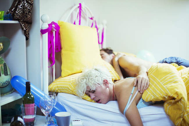 Jovem casal dormindo na cama de manhã depois de uma festa — Fotografia de Stock