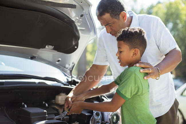 Grandfather and grandson repairing car engine — Stock Photo