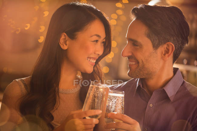 Casal tostando flautas de champanhe juntos — Fotografia de Stock
