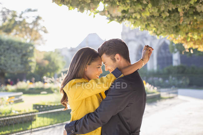 Молода пара обіймається в міському парку — стокове фото
