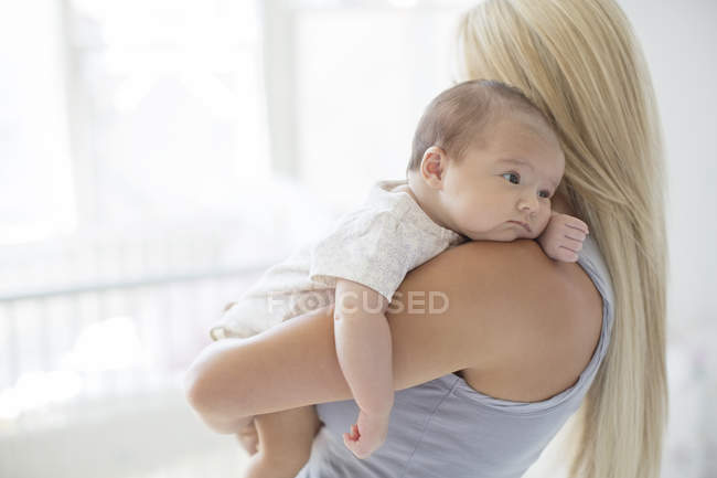 Mother holding baby girl in nursery — Stock Photo