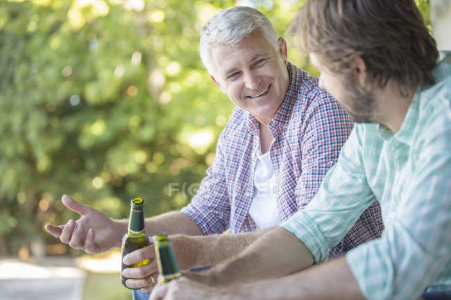 Father and son drinking outdoors — Stock Photo